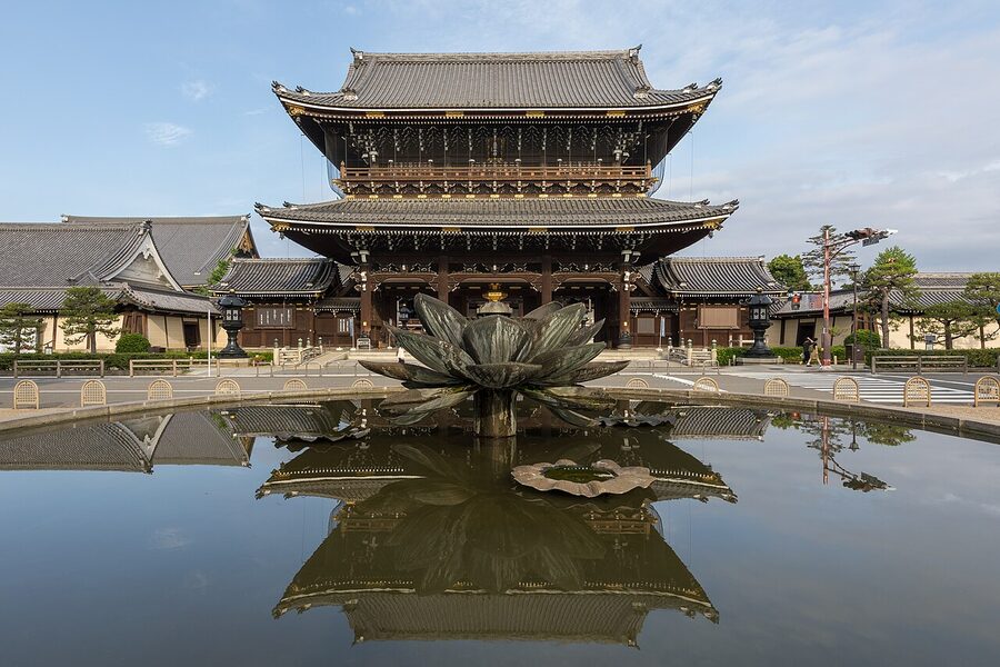 The Founder's Hall gate of Higashi Honganji reflected in a rainwater pool on the temple forecourt