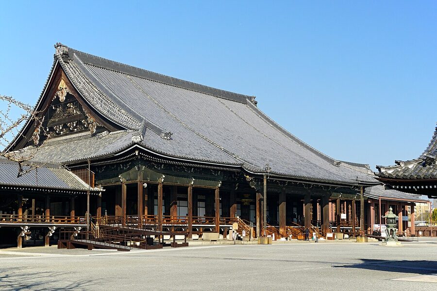 Nishi Honganji temple's main hall with curving roof lines against a clear sky